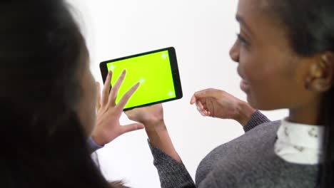 dos mujeres de negocios trabajando en tableta