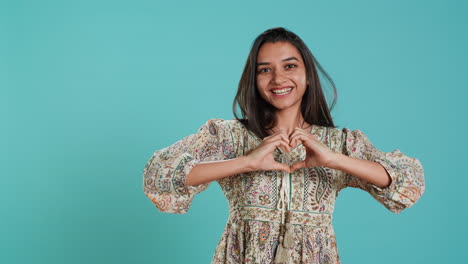 Retrato-De-Una-Mujer-Amorosa-Sonriente-Haciendo-Gesto-Con-Forma-De-Símbolo-De-Corazón