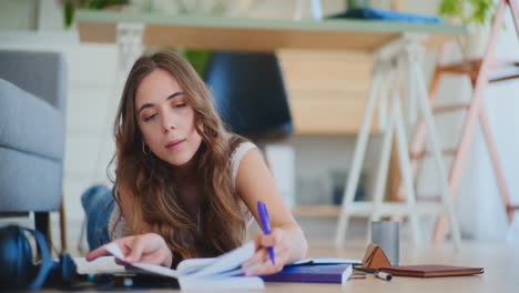 mujer acostada en el suelo abriendo un libro