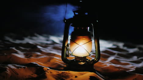 vintage oil lamp standing on the sand shines in the dark prores 422 10 bit video