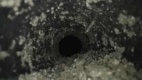 macro slider shot through underground tunnel pipe covered in dirt and mud