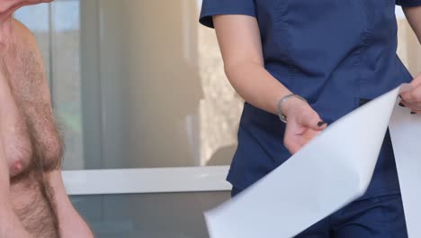 a cardiologist performs an ecg on the heart. the doctor analyzes the electrocardiogram. a doctor looks at a cardiogram in a medical office.