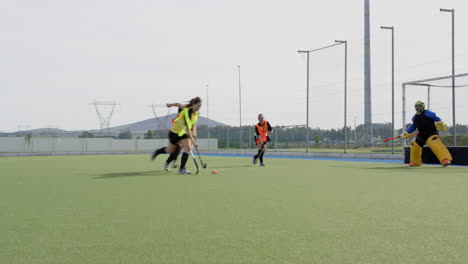 competing intensely, female hockey players focusing on teamwork and strategy on field