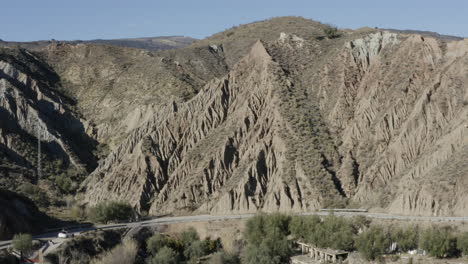 dramatic rocky formation on a hilly mountain side with a road along the bottom