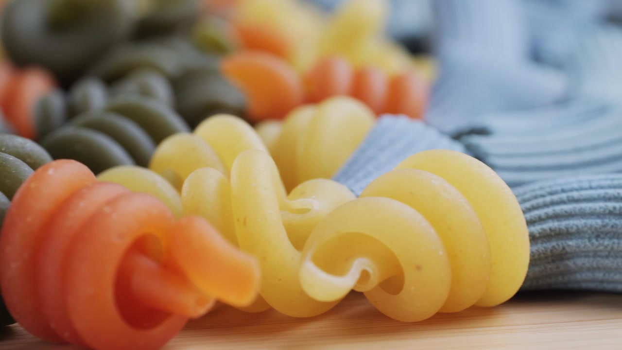 Panoramica ravvicinata di varietà di pasta cruda colorata