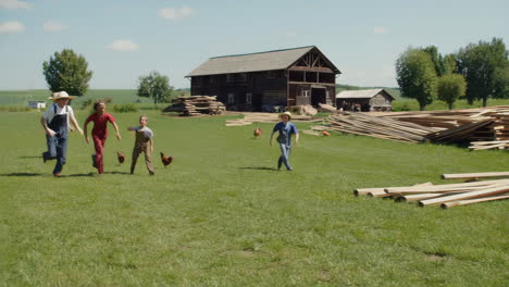 children playing and running on a farm with hay bales and chickens