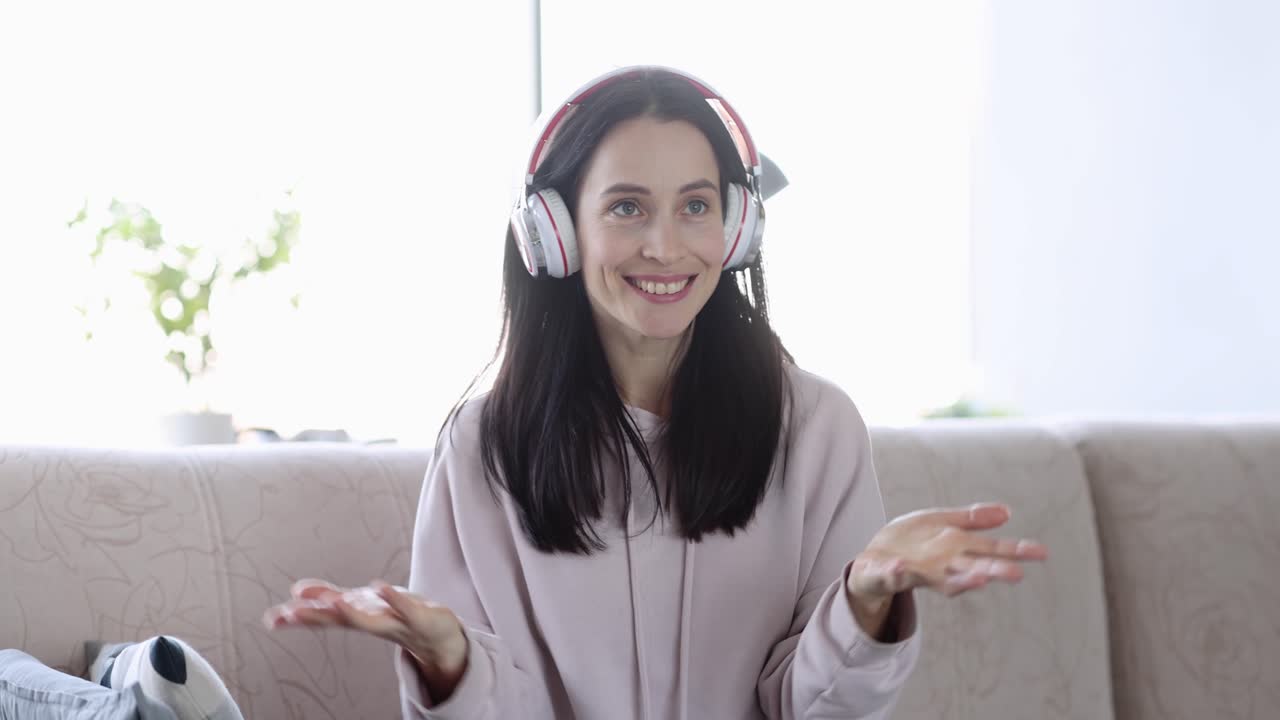 Donna con le cuffie effettua una videochiamata e comunica online