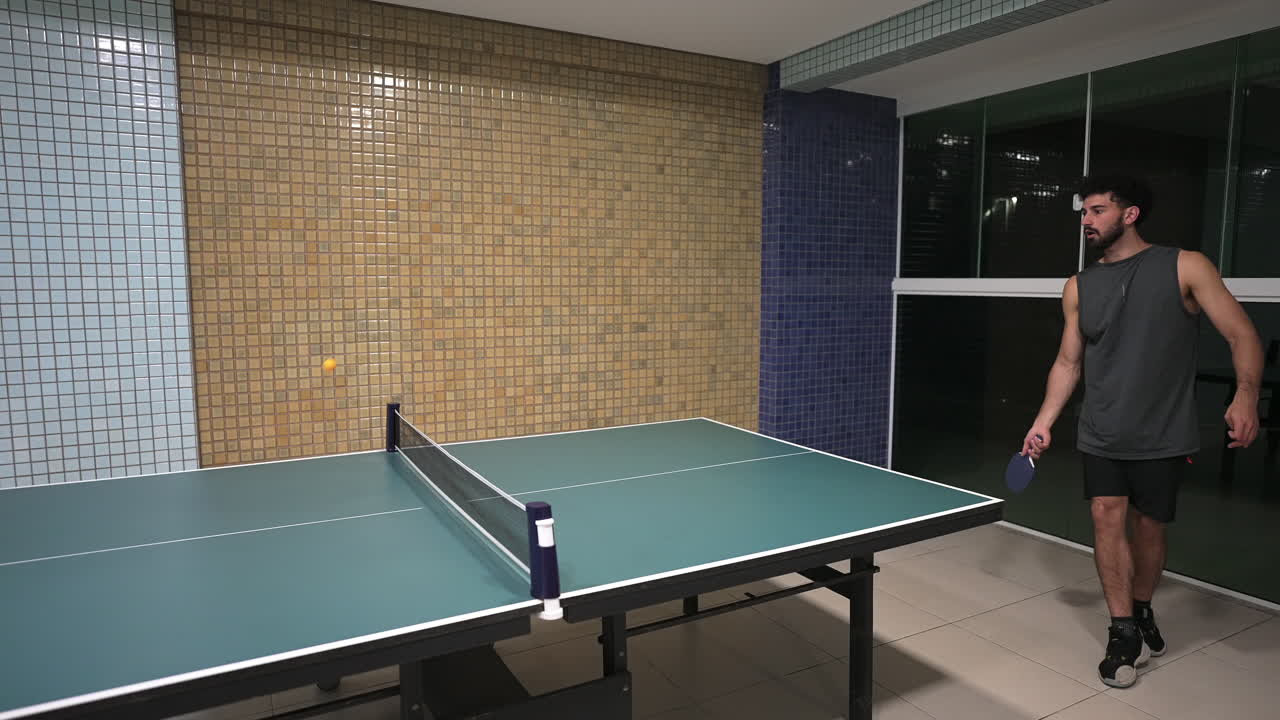 A static time-lapse captures the fast and energetic action of a Brazilian man playing table tennis, his quick movements and the sped-up rally creating a dynamic and exciting sports clip