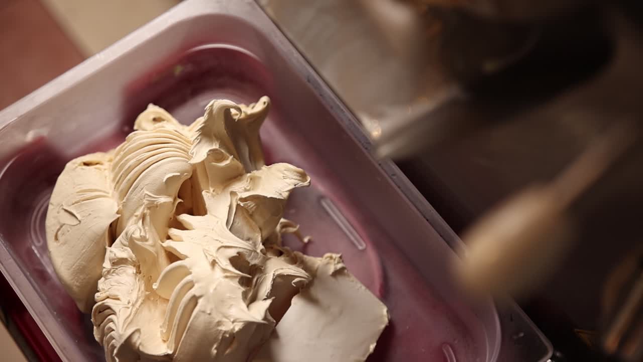 Primo piano di gelato cremoso in un contenitore di plastica