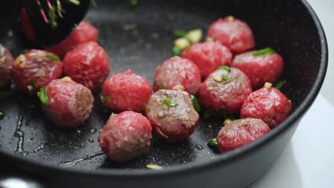 persona irreconocible cocinando albóndigas en sartén con aceite