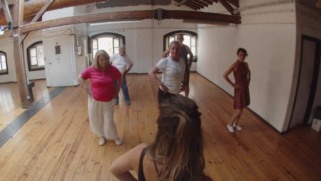 long shot of senior people having dance class with instructor