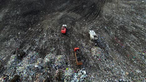 aerial view of landfill with garbage trucks
