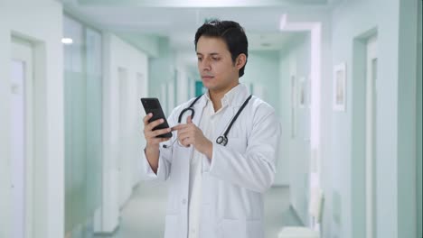 indian doctor scrolling through phone