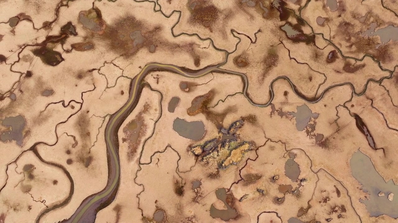 Rios de maré sinuosos fluindo através da paisagem costeira marrom da Islândia. Vista aérea.