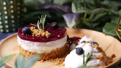 cheesecake with berry sauce set on wooden plate.