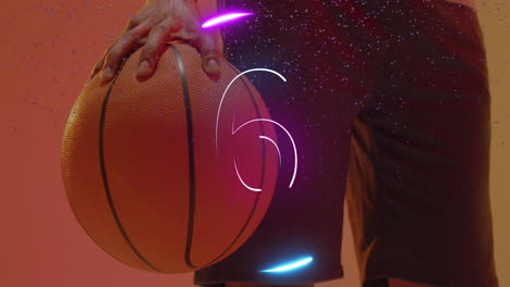 animation of number countdown and ring over african american male basketball player holding ball