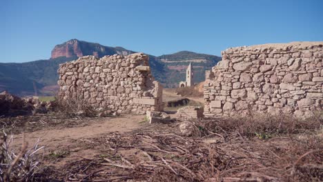 old buildings emerging from empty swamp due to the problems of extreme dryness and lack of rain