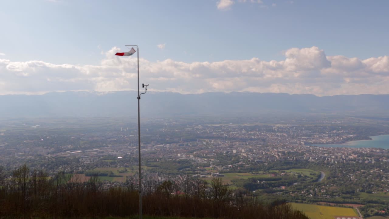 화창한 날 구름과 함께 계곡 뒤에 제네바가 있는 산꼭대기에서 날아가는 바람막이, 여전히 광각 샷