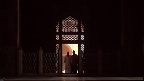 elderly man walking through an ornate doorway