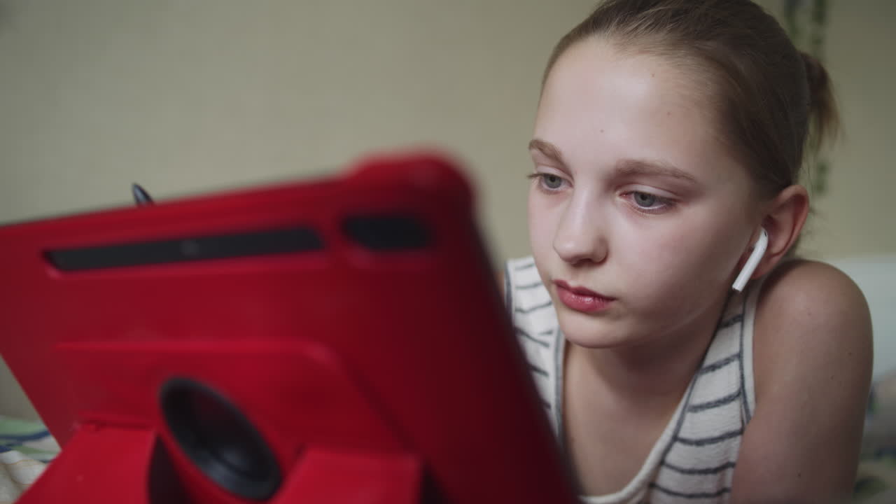 Teenage Girl Using Tablet in Bedroom