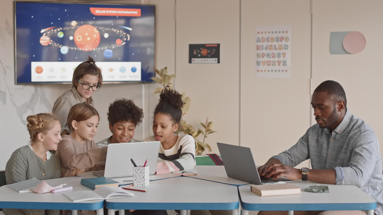Cheerful Students and Teacher in Science Class with Laptops