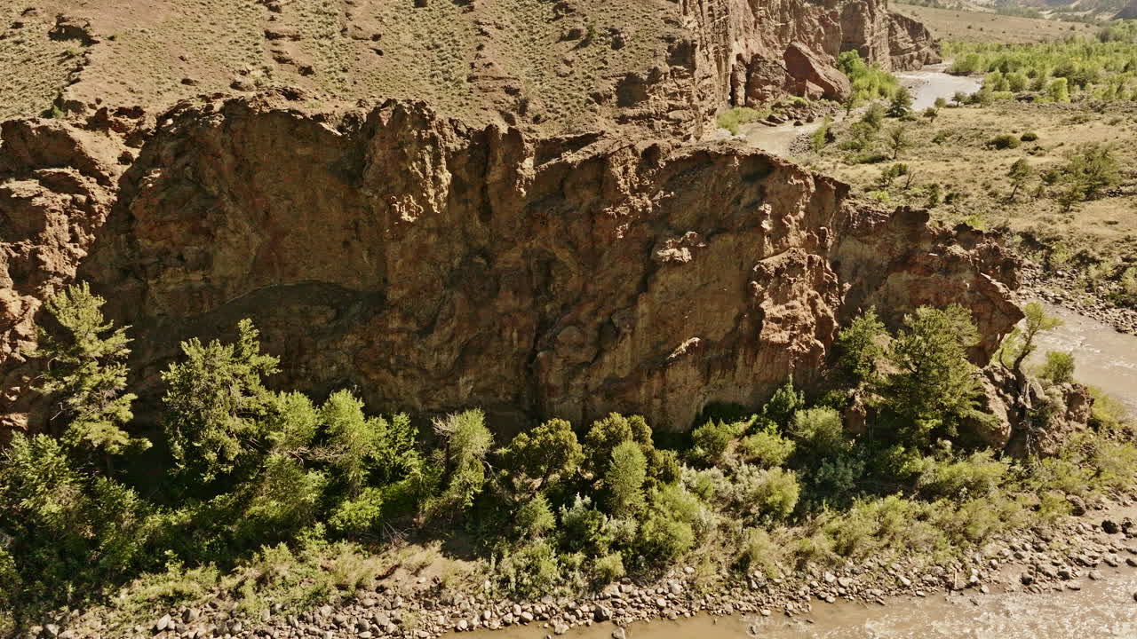 Drone shot revealing layers of colorful sedimentary rock in the western United States.