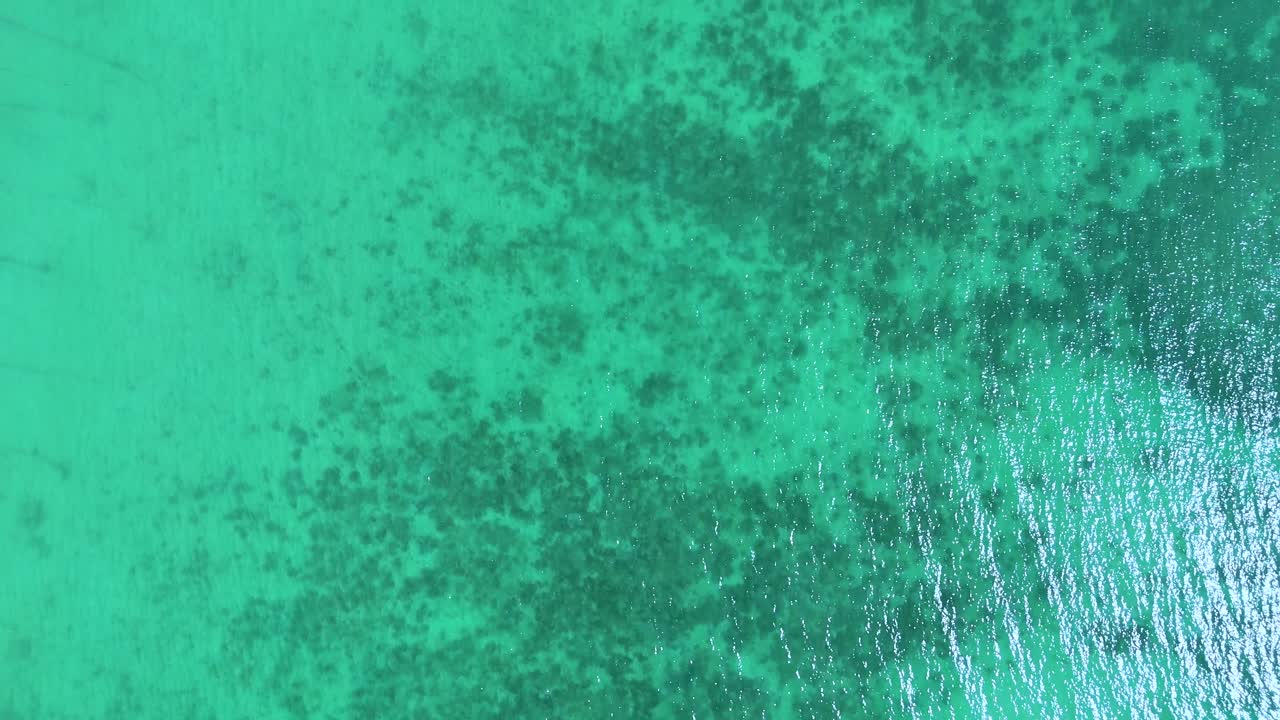 Drone footage captures vibrant coral reefs in Phuket's turquoise waters, showcasing natural beauty and marine diversity from above
