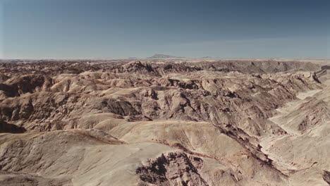 arid desert landscape with dramatic hills and valleys