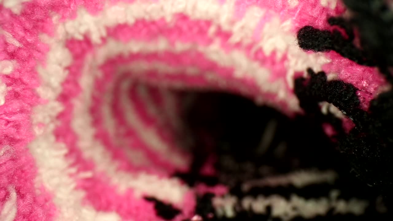 sacando un calcetín de color rosa brillante, blanco y negro