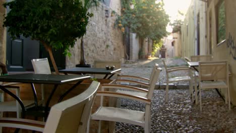 some empty chairs by an empty , quite street in rhodes