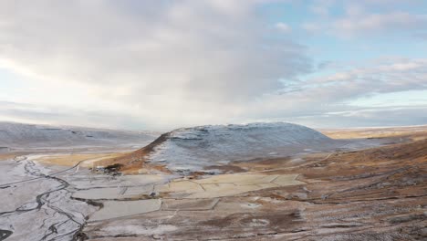 aerial view of picturesque valley and snowcapped volcanic hills and sky, iceland panoramic drone shot of scenic landscape