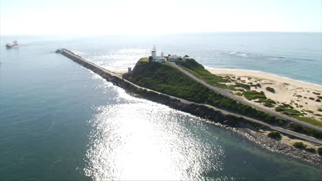 Aerial-shots-of-cargo-container-ship-entering-Newcastle-harbour,-Australia-carrying-beer-vessels