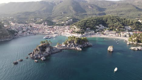 dolly aérea sobre bahía escénica con islotes en el mar jónico hacia la ciudad costera de parga