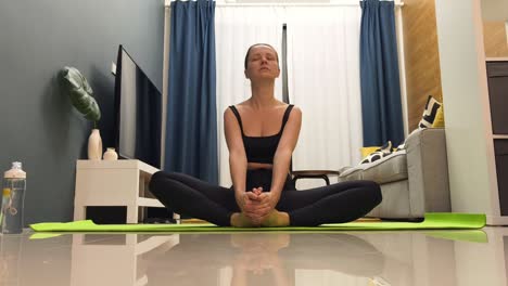 mujer practicando posturas de yoga en casa