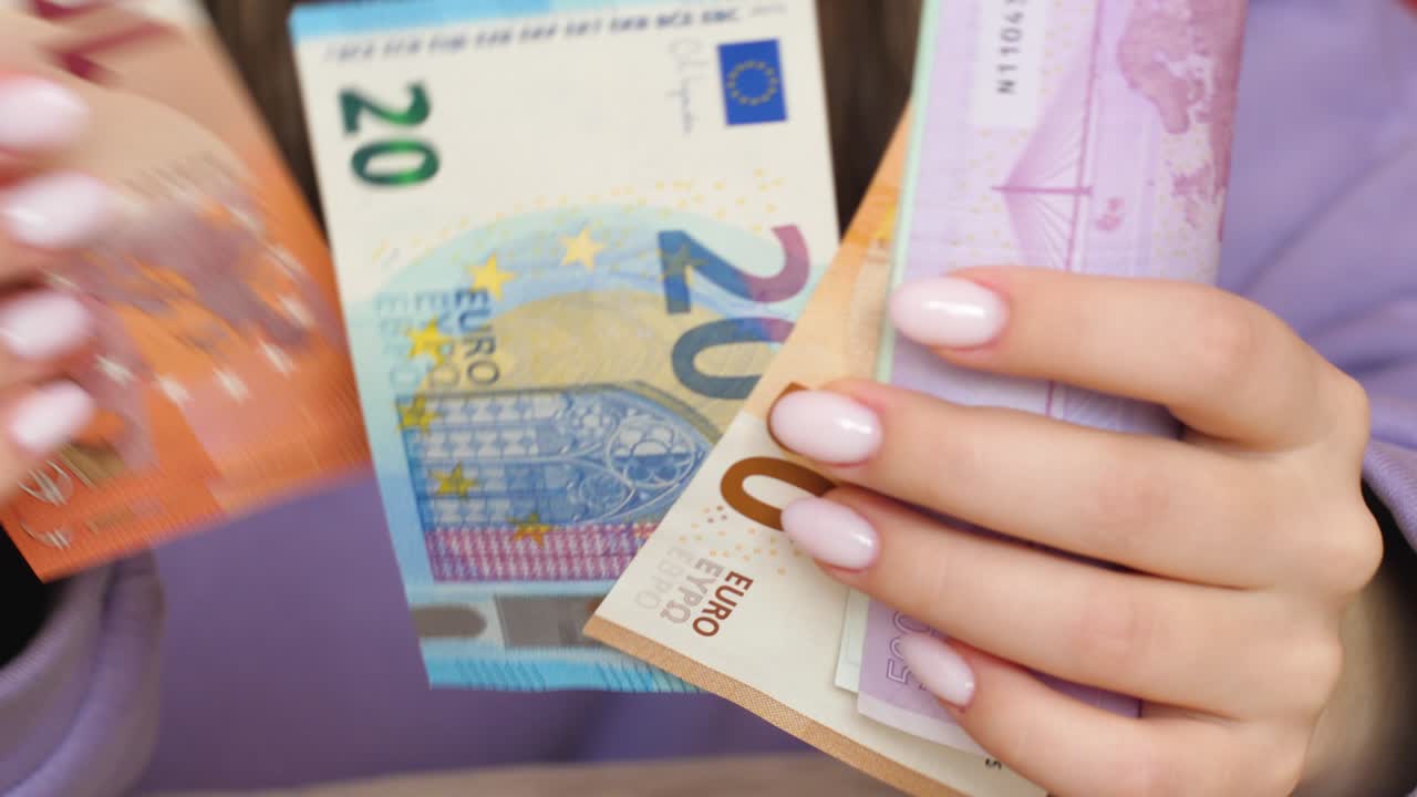 여성이 손에 들고 있는 20, 50, 100, 500 유로 지폐를 세우고 있는 현금.