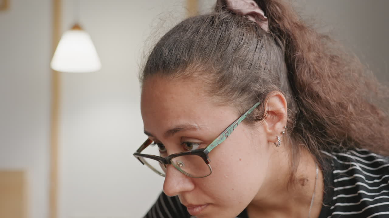 Donna in camera d'albergo concentrata su prenotazione e lavoro, l'ospite rivede i dettagli della prenotazione alla scrivania sotto una luce soffusa, interni moderni e tranquilli, espressione pensierosa ed emozione sottile.