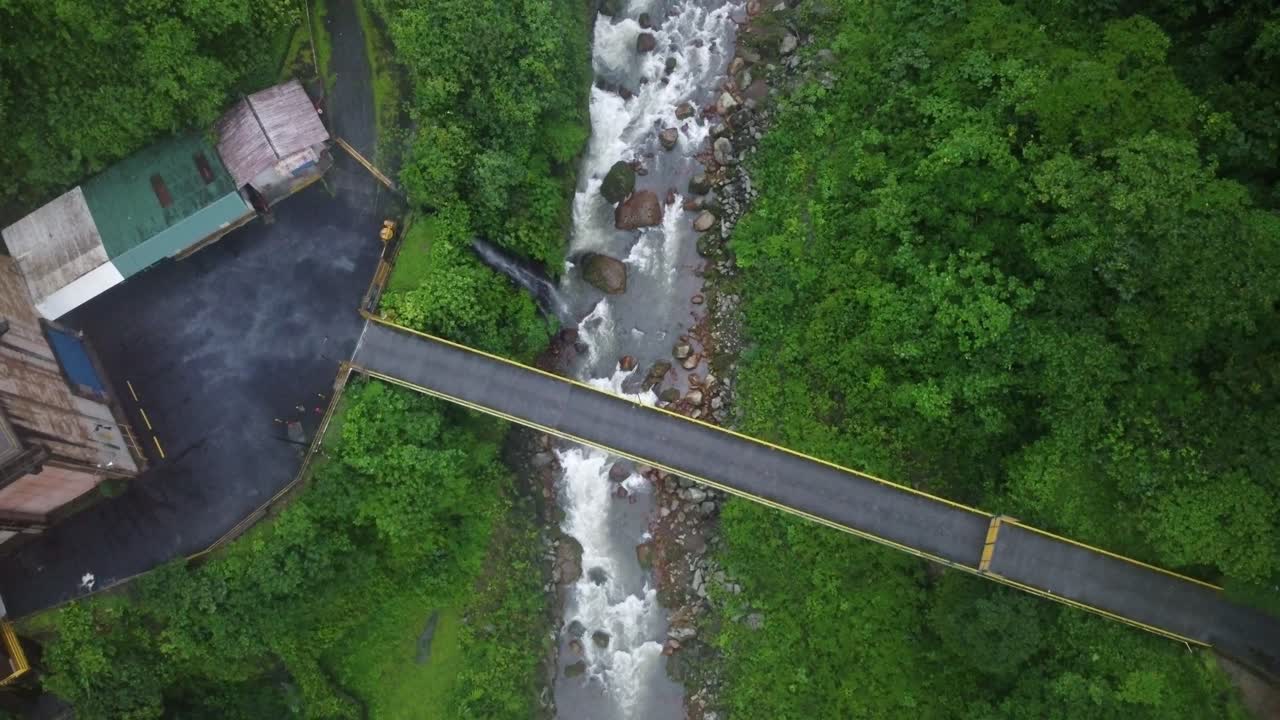 An aerial view of a river and a bridge on the Quebrada Gata trail in Costa Rica with and old water Treatment Plant