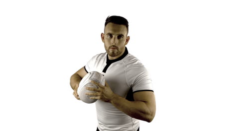 jugador de rugby serio sostiene la pelota de rugby