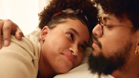 a loving couple in bed, looking at each other with tenderness.