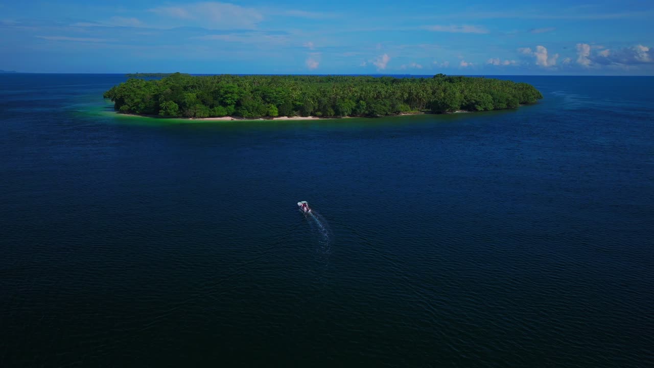 Fishing boat Yuo Island remote pristine untouched tropical coastline village Wewak Madang Cape Wom Papua New Guinea aerial drone PNG dry season summer morning blue sky follow forward pan up motion