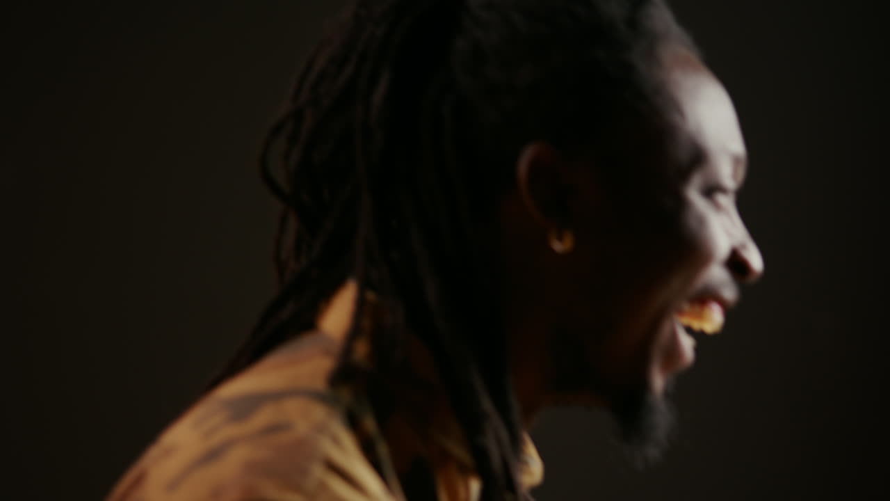 아프리카계 미국인 남자가 검은색 배경에서 재미를 느끼고 있습니다.