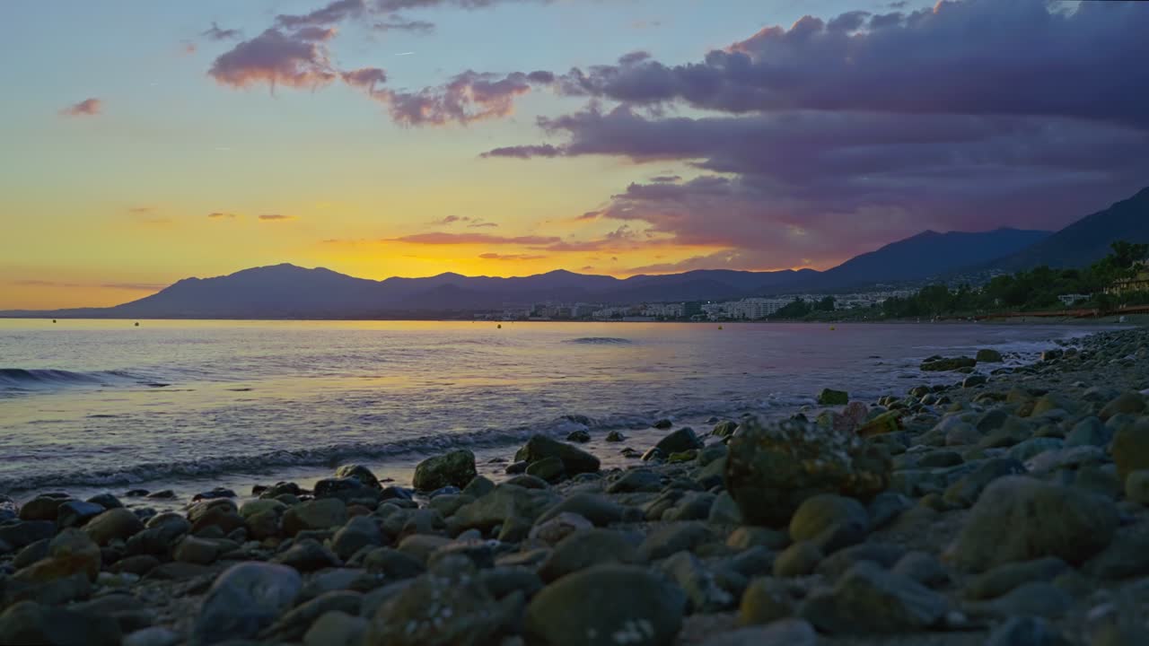 playa rocosa después del atardecer en marbella, españa