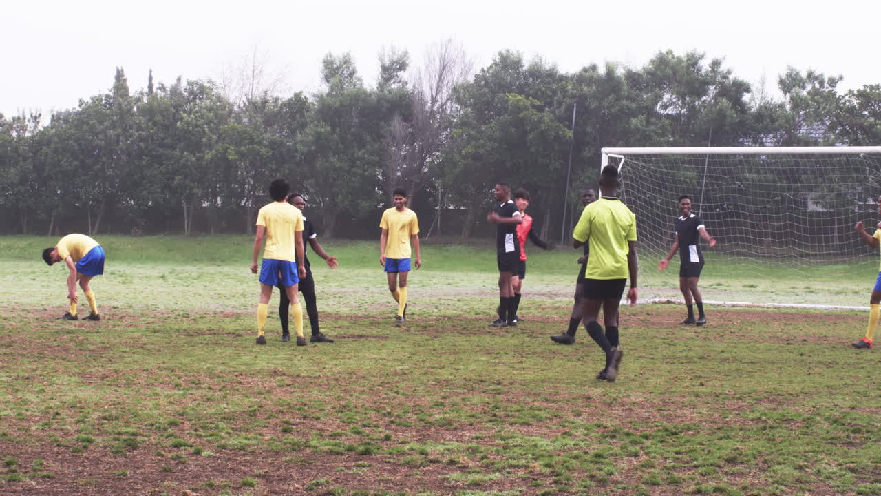 Soccer players discussing strategy on field during practice session outdoors