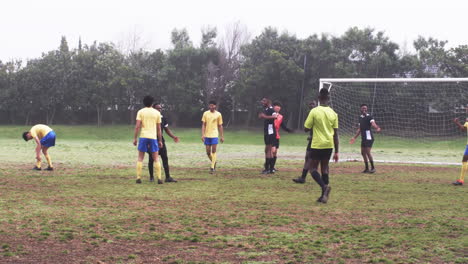 soccer players discussing strategy on field during practice session outdoors