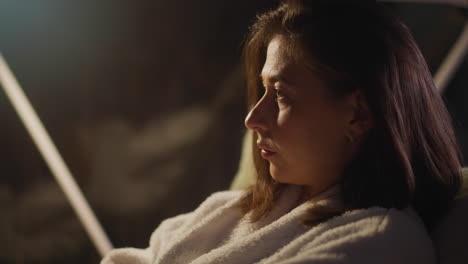 woman looking out of window on calm night overcomes by sense of melancholy and feels pain of loneliness. lonely female calms down and relaxes closeup