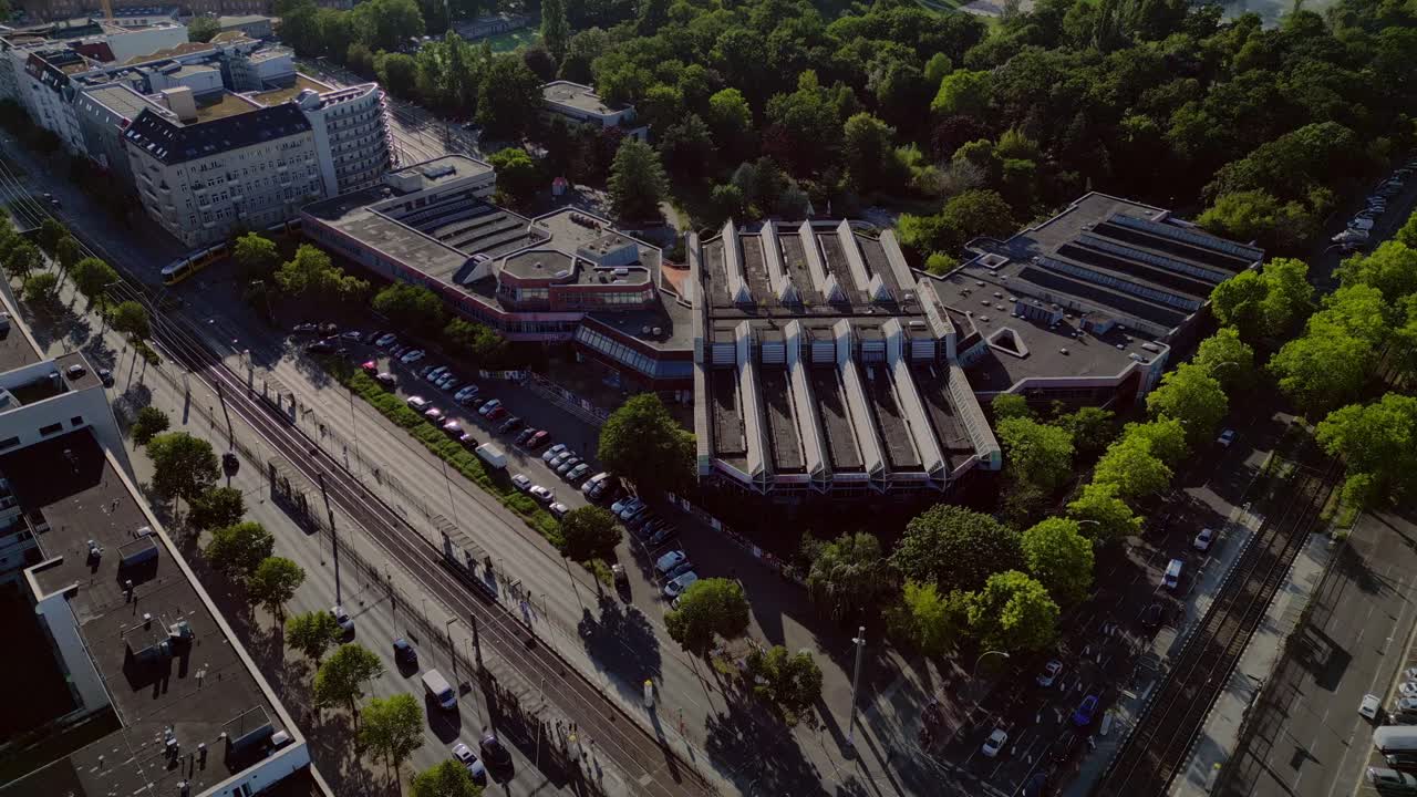 Sez and Volkspark Friedrichshain in Berlin, showcasing its lush greenery, a passing tram on a sunny day. Magic aerial view flight drone shot from above