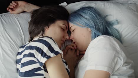 close up video of lesbian couple sleeping on bed.