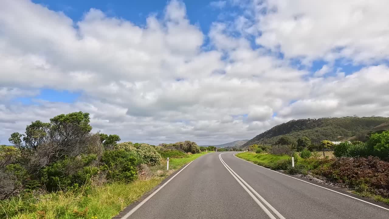 A 15-second journey along the Great Ocean Road, showcasing coastal landscapes under bright, partly cloudy skies