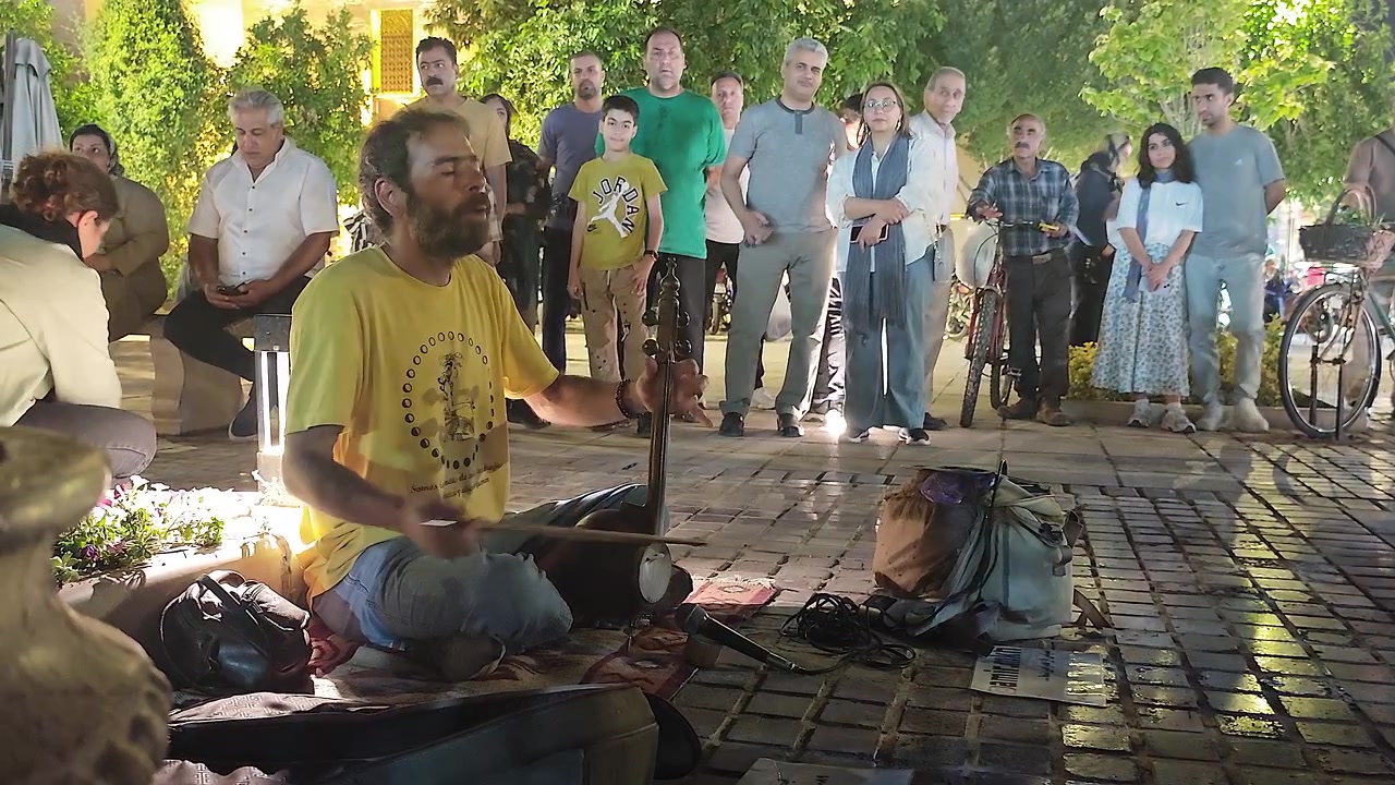 Gademusiker spiller traditionelt strengeinstrument for et publikum