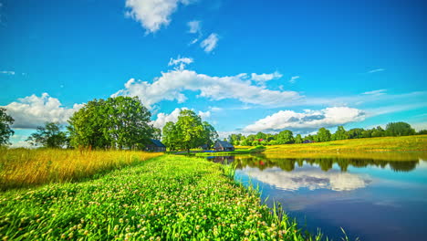 Dusk-to-dawn-timelapse-of-beautiful-landscape-with-lake-and-green-vegetation-blue-sky-and-clouds